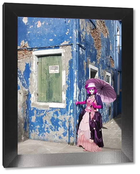 Woman in pink costume holding umbrella during Carnival, Island of Burano, Venice