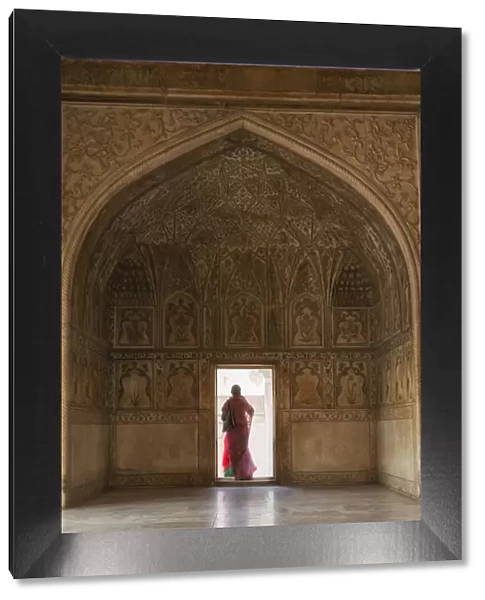 India, Uttar Pradesh, Agra, Agra Fort, a woman in a red saree walks through the interior