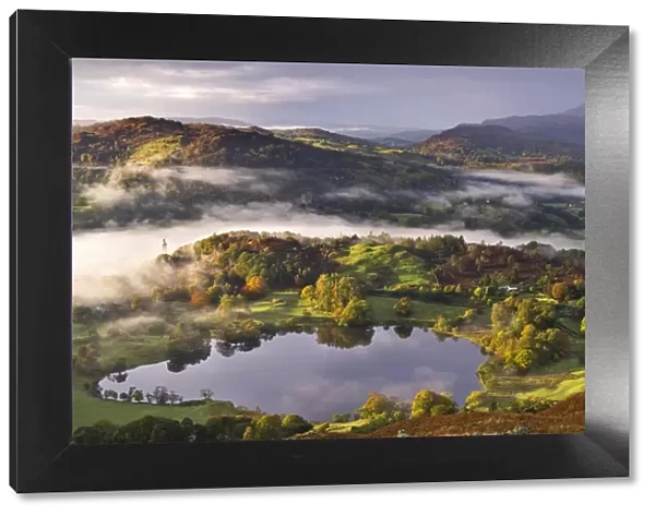 Loughrigg Tarn surrounded by misty autumnal countryside, Lake District, Cumbria, England