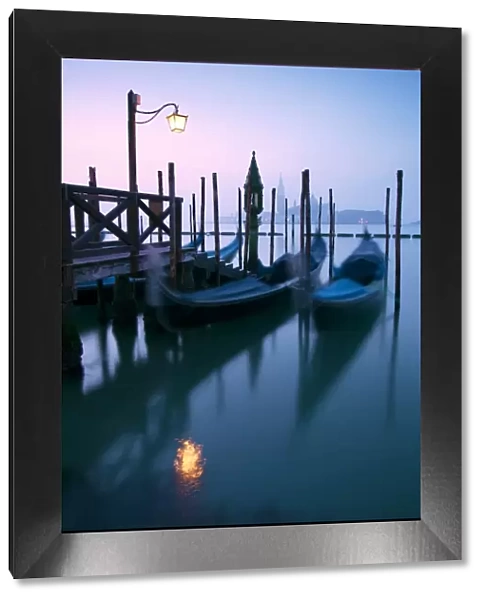 Italy, Venice. Gondolas moored on Riva degli Schiavoni at sunrise