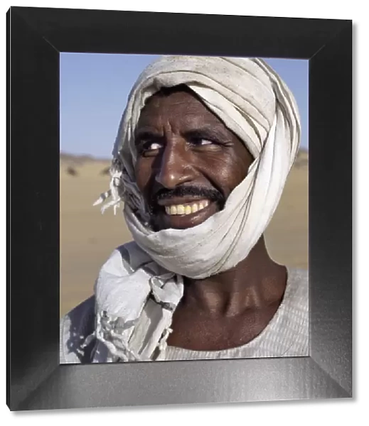 A Nubian man wearing a white turban smiles broadly at his friend