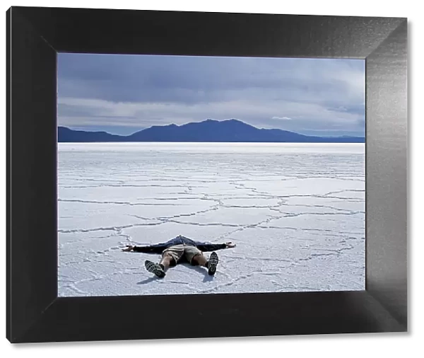 A tourist lies on the salt crust of the Salar de Uyuni