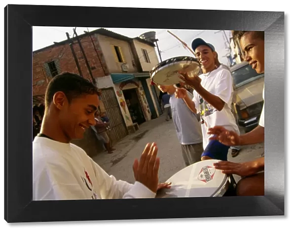 Teenage boys drum and play the tambourine in their neighborhood in Sao Paulo