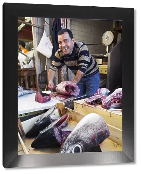 A fishmoger prepares fresh tuna