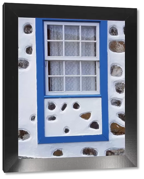 Detail of a window on a whitewashed house with inset
