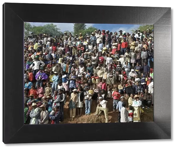 A large crowd of Malagasy people watch a zebu Savika