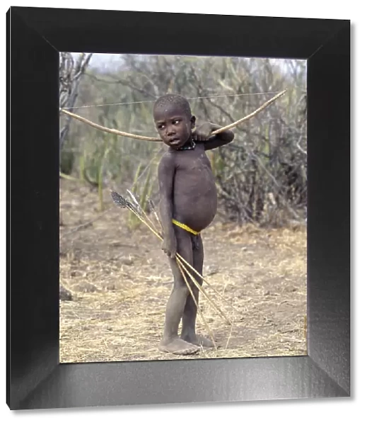 A Hadza boy carrying a bow and arrows