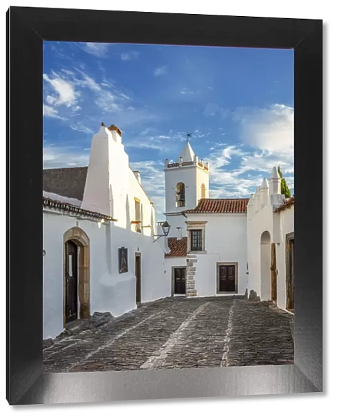 Portugal, Alentejo, Monsaraz. Cobbled streets leading to the bell tower gateway of the