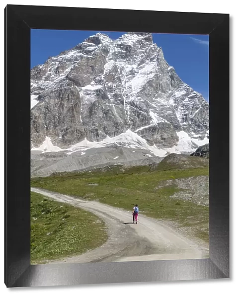 A lonely person hiking under the Matterhorn (Cervino) during a sunny summer day in the Italian Alps