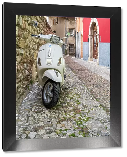 Piaggio Vespa scooter parked in a cobbled street of Malcesine, Lake Garda, Veneto, Italy