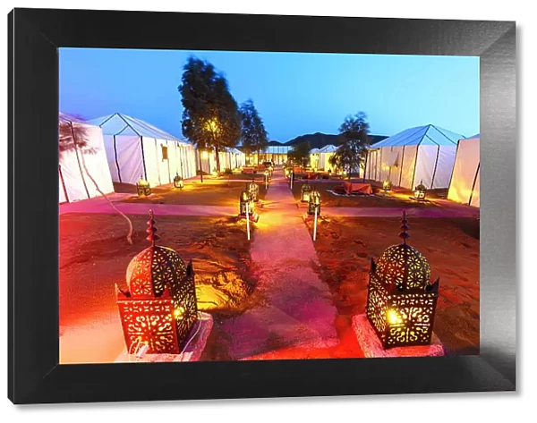 Luxury desert camp for tourists lit by lanterns at dusk, Erg Chebbi, Merzouga, Sahara Desert, Morocco