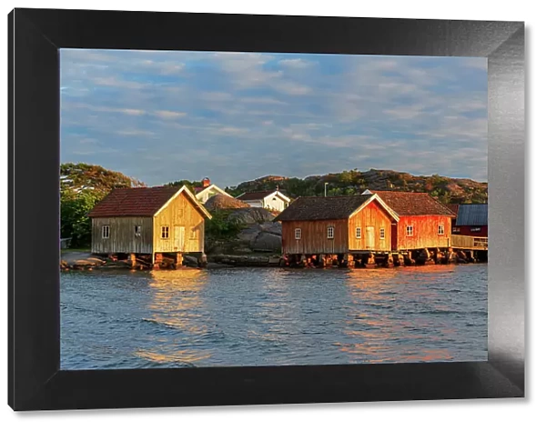 Colored and old fishing houses lit by sunset, Bohuslan, Sweden, Scandinavia