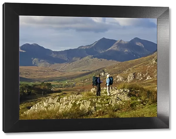North Wales, Snowdonia. A man and woman stop to look at their map whilst hiking in Snowdonia