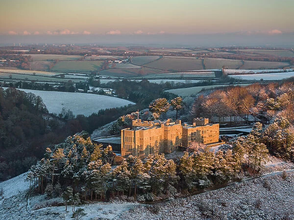 Aerial view of Castle Drogo on a snowy winter morning, Dartmoor, Devon, England. Winter (December) 2023