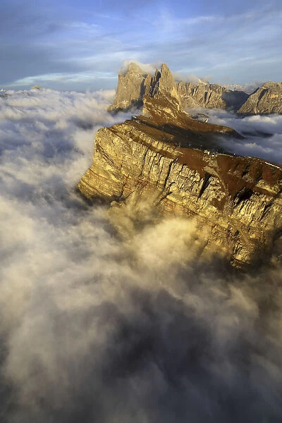 Aerial view from Seceda of Odle surrounded by clouds at sunset