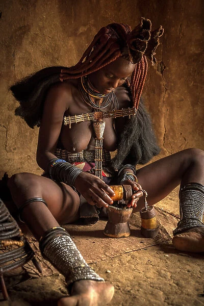 Africa, Namibia, Kamanjab. A himba woman preparing the smoke to deodorize herself