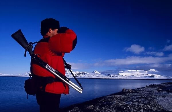 Armed guide checking for polar bears prior to land excursion