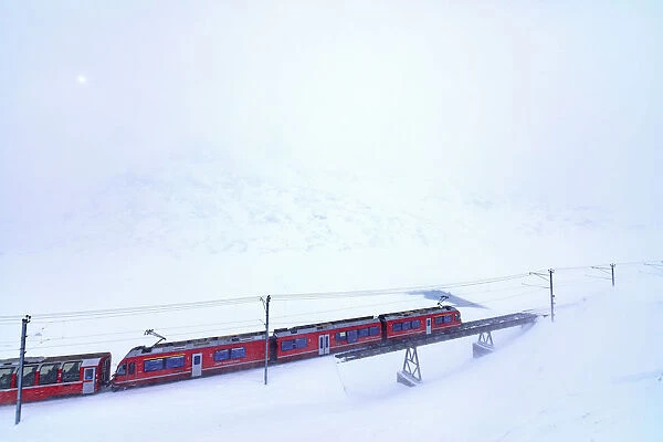 Bernina Express train at Bernina Pass during a snowstorm, canton of GraubAonden, Engadin