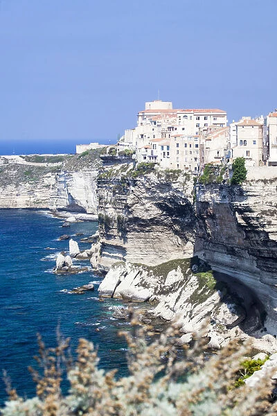 Blue sea frames the medieval old town and fortress perched on top of cliffs Bonifacio