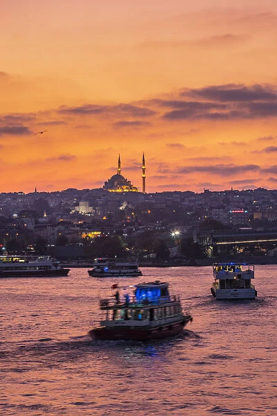 Boats in the Golden Horn at sunset with a Mosque in the background. Istanbul, Turkey