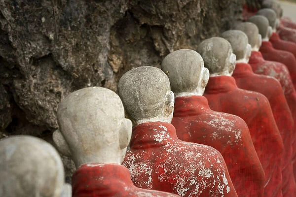 Many Buddhist monk statues standing in a row at Kaw Ka Thaung Cave, Hpa-an