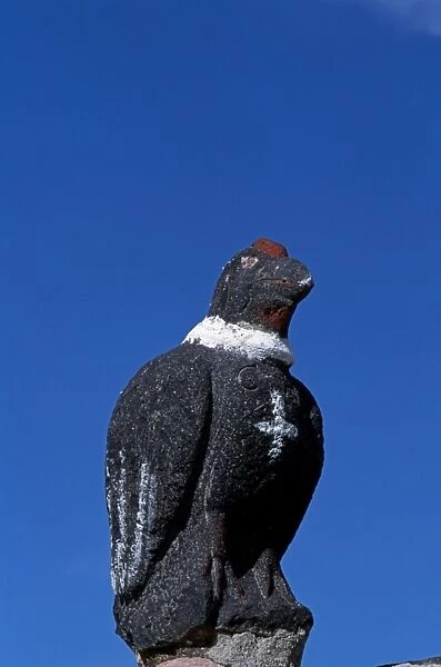 A carved stone condor stands on the gatepost of the