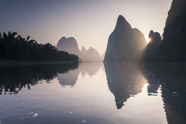 China, Guanxi, Yangshuo. Sunrise over Li river and karst peaks