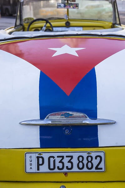 Classic American car with the Cuban flag painted in its boot, Parque Central