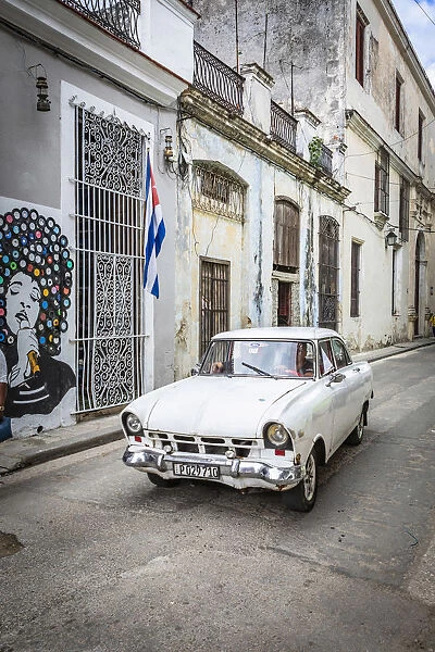 Classic car driving in a narrow street in La Habana Vieja (Old Town), Havana, Cuba