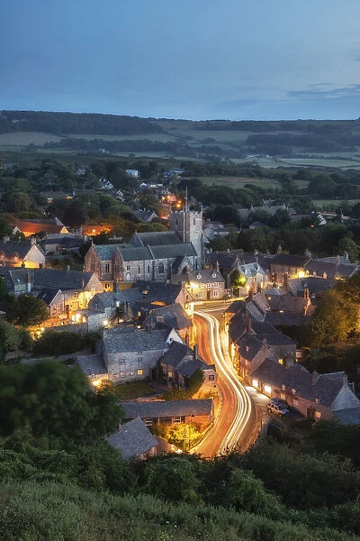 Corfe Castle village at dusk viewed from East Hill, Dorset, England, UK