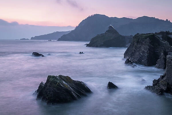 Dawn pink sky above Ilfracombe's rugged coast from Capstone Hill, Ilfracombe, Devon, England. Spring (April) 2023