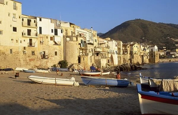 Fishing boats pulled up on the beach outside the old town at sunset