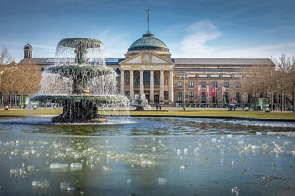 Fountain and icy pond at the bowling green in front of the Kurhaus, Wiesbaden, Hesse, Germany