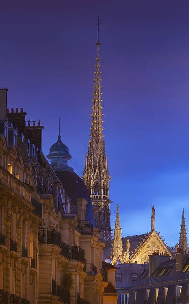 France, Paris, Notre Dame Cathedral, spire above rooftops at dusk