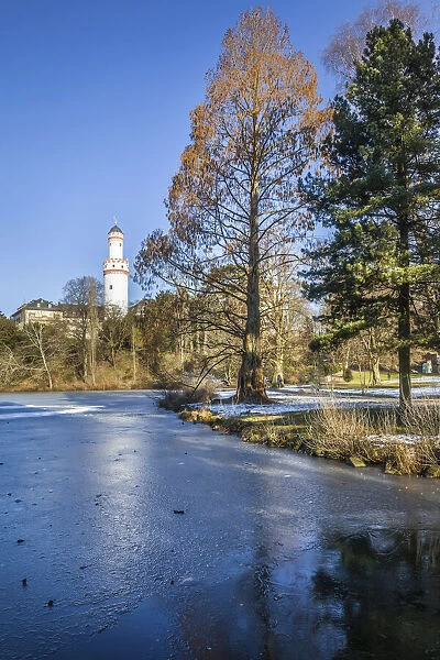 Frozen pond in the palace gardens of Bad Homburg vor der Hoehe with white tower, Taunus, Hesse, Germany