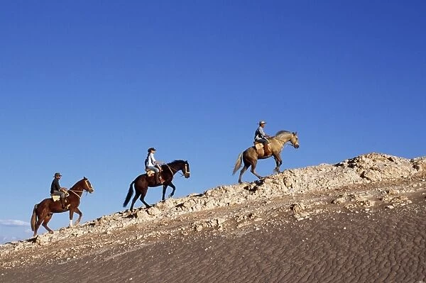 Horse riding along a ridge amongst the wind-eroded