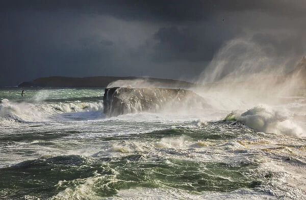 Hoyviksholmur hit by rough ocean. In the backgorund the island of Nolsoy. Streymoy, Faroe Islands