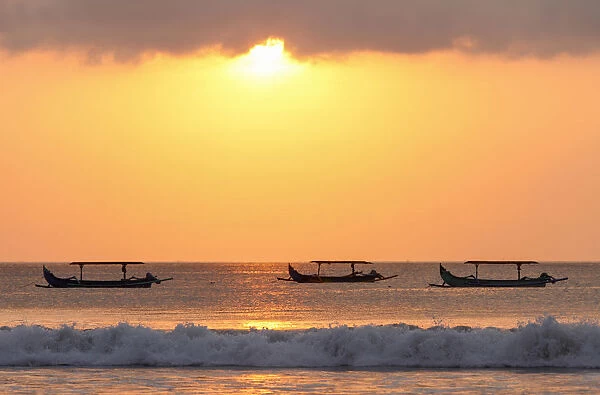 Indonesia, Bali, Kuta; fishing outriggers on the beach of Kuta; at sunset