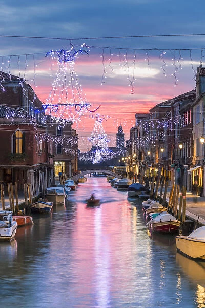 Italy, Veneto, Venice, Murano island. Canal at sunset with Christmas lights hanging
