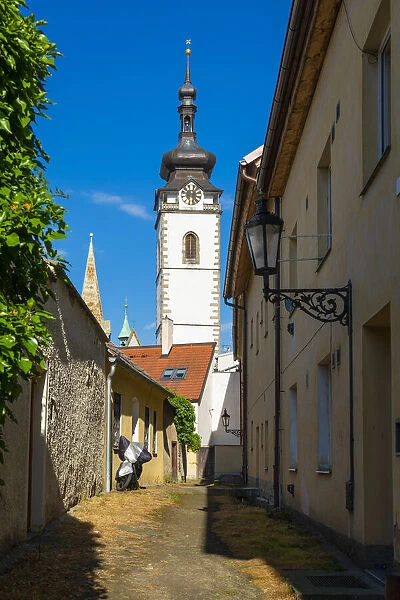 Lane towards tower of Church of the Nativity of the Blessed Virgin Mary on sunny day, Pisek, South Bohemian Region, Czech Republic