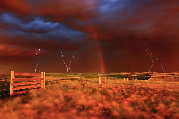 Lightning strikes, rainbow and setting sun during prairie storm. West Block Grasslands National Park Saskatchewan, Canada
