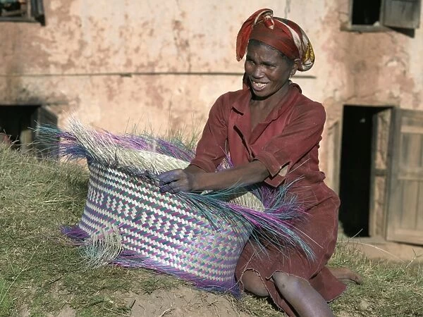 A Malagasy woman weaves a basket from raffia palm