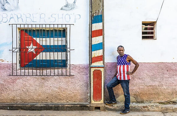 A man standing outside a barber shop in La Habana Vieja (Old Town), Havana, Cuba