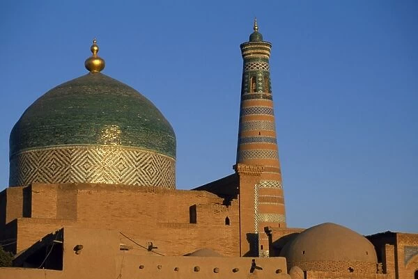 The minaret and tiled dome of a mosque rise above the