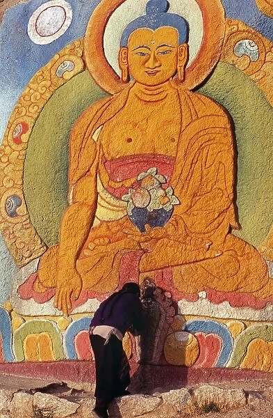 A monk bows before an image of a deity, Sera Monastery
