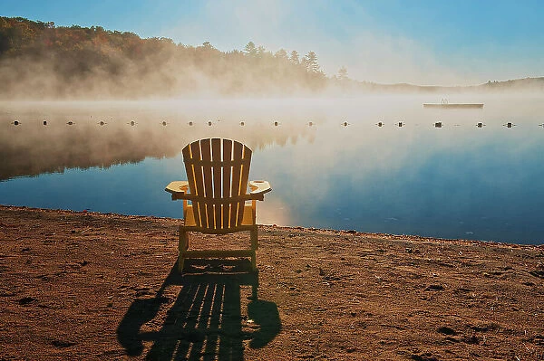 Muskoka chair in morning fog on sandy beach of Silent Lake Silent Lake Provincial Park, Ontario, Canada