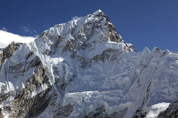 Nepal, Everest Region, Khumbu Valley. A helicopter having carried out a rescue from the Everest Base Camp is dwarfed by the Everest Massif on its return