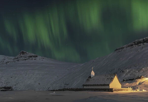 Northern lights above the church in Saksun. Streymoy, Faroe Islands