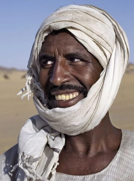 A Nubian man wearing a white turban smiles broadly at his friend