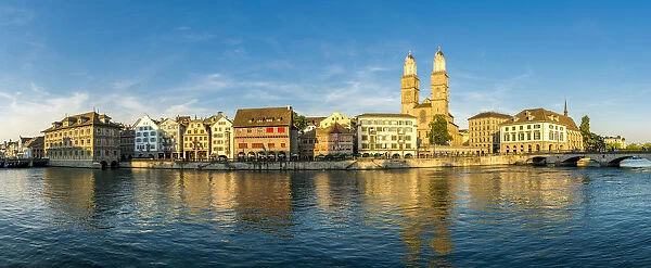 Panoramic of Limmatquai and Grossmunster Cathedral along Limmat River at sunset, Zurich